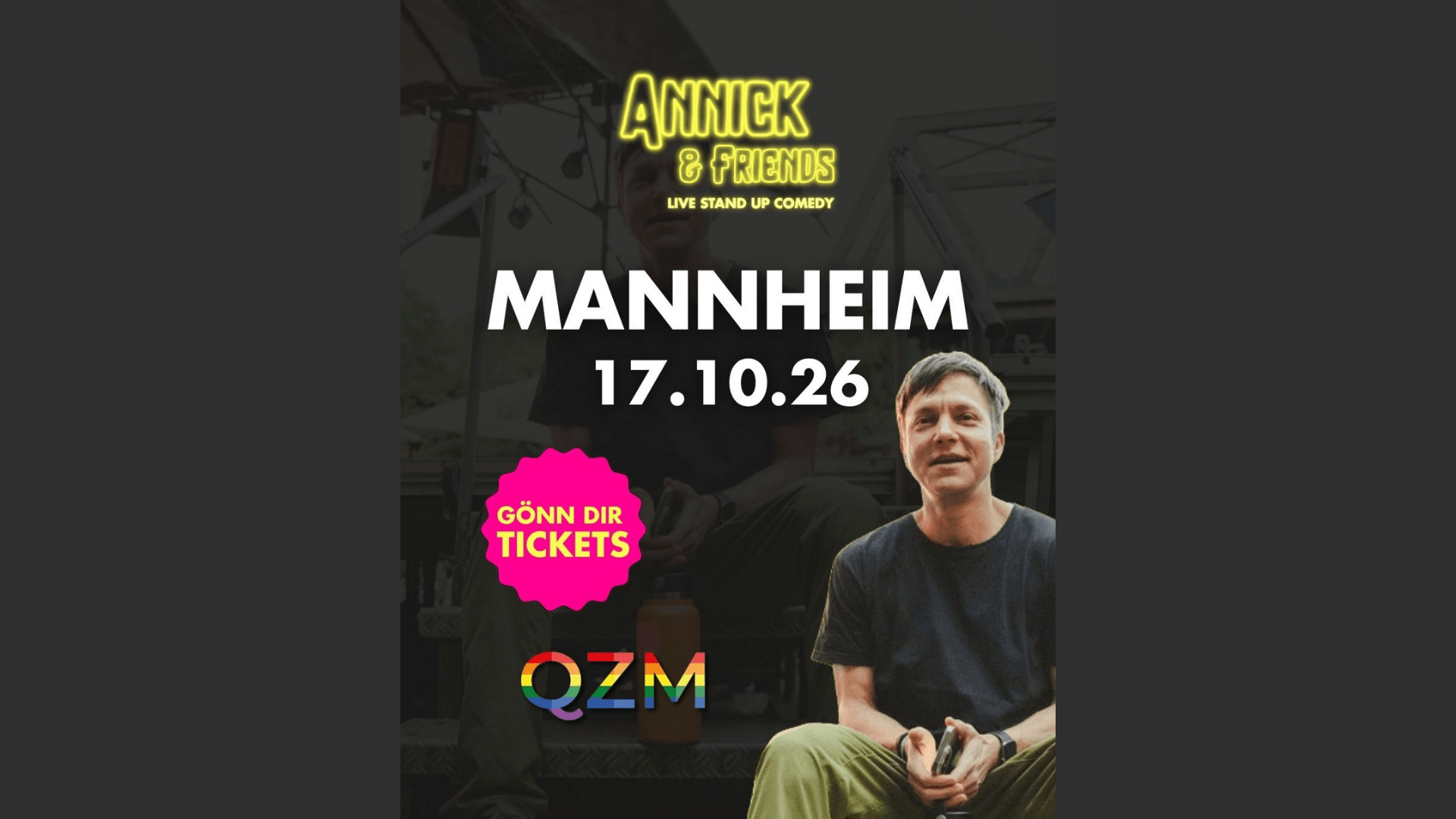 Vor dunkelgrauem Hintergrund sieht man Annick Adelle sitzend in die Kamera lächeln. Unten links sieht man das Logo des QZM. Oben auf dem Bild steht "Annick and friends - live standup comedy" in gelber leuchtender Schrift.