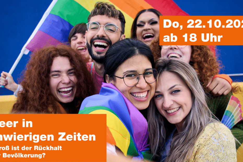Eine Gruppe Personen lächeln in die Kamera und halten eine Regenbogenflagge.